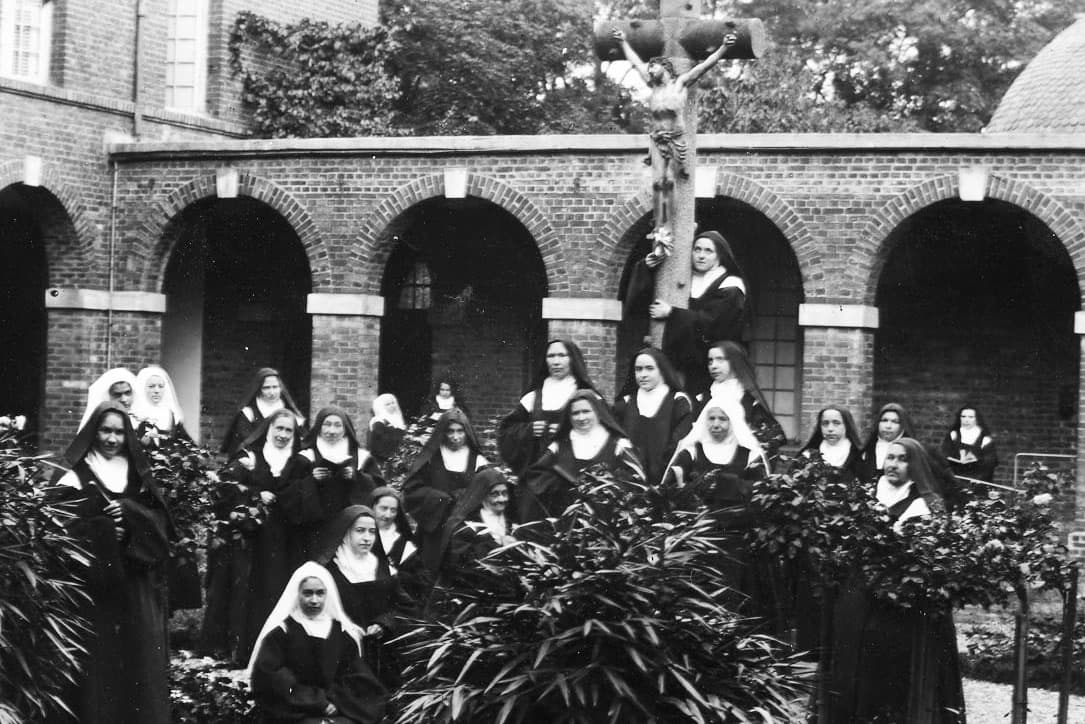 Group shot of the sisters at Carmel, Lisieux. St. Therese is uppermost, embracing the crucifix.
