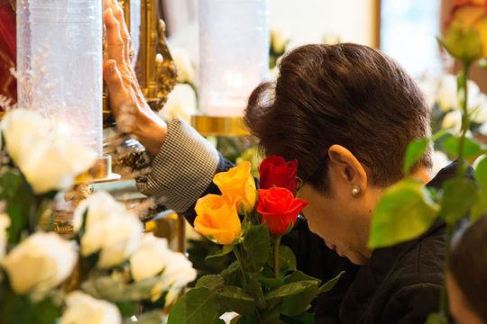 Woman venerating St. Therese's relics at Feast Day Celebration