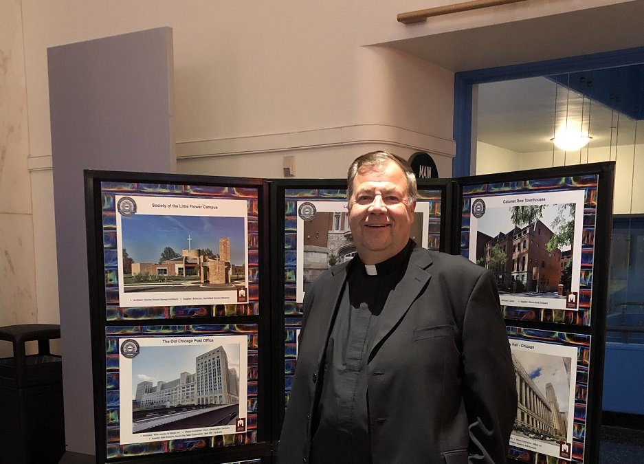 Fr. Thomas Schrader, O. Carm. standing in front of the new awards